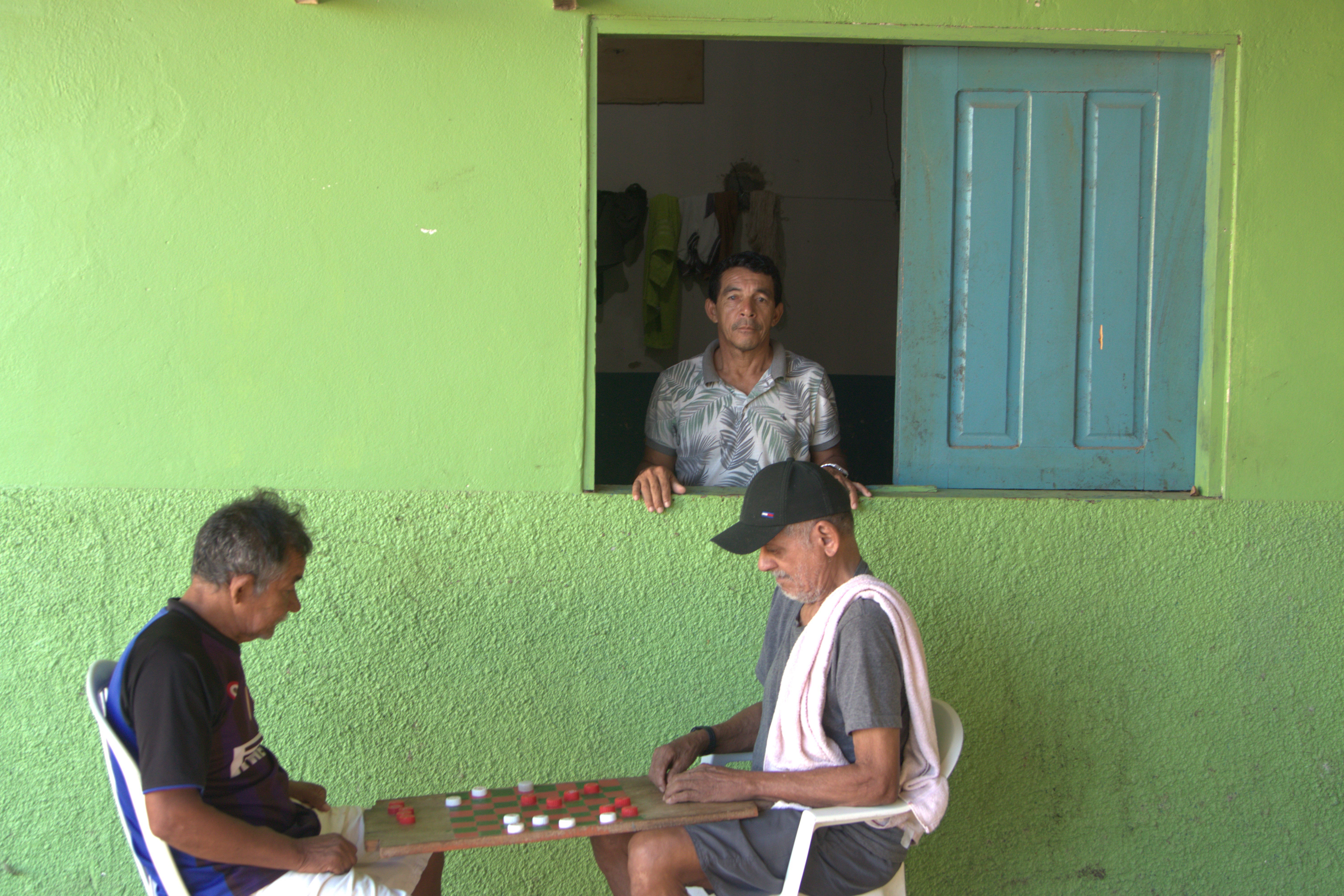 Two men playing a game one is looking out a window