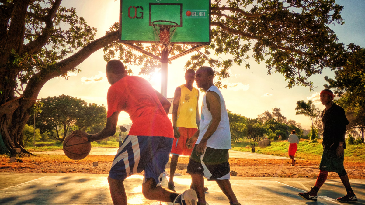Young men playing basketball outdoors, Dar as Salaam, Tanzania. Photo by Rohan Reddy on Unsplash